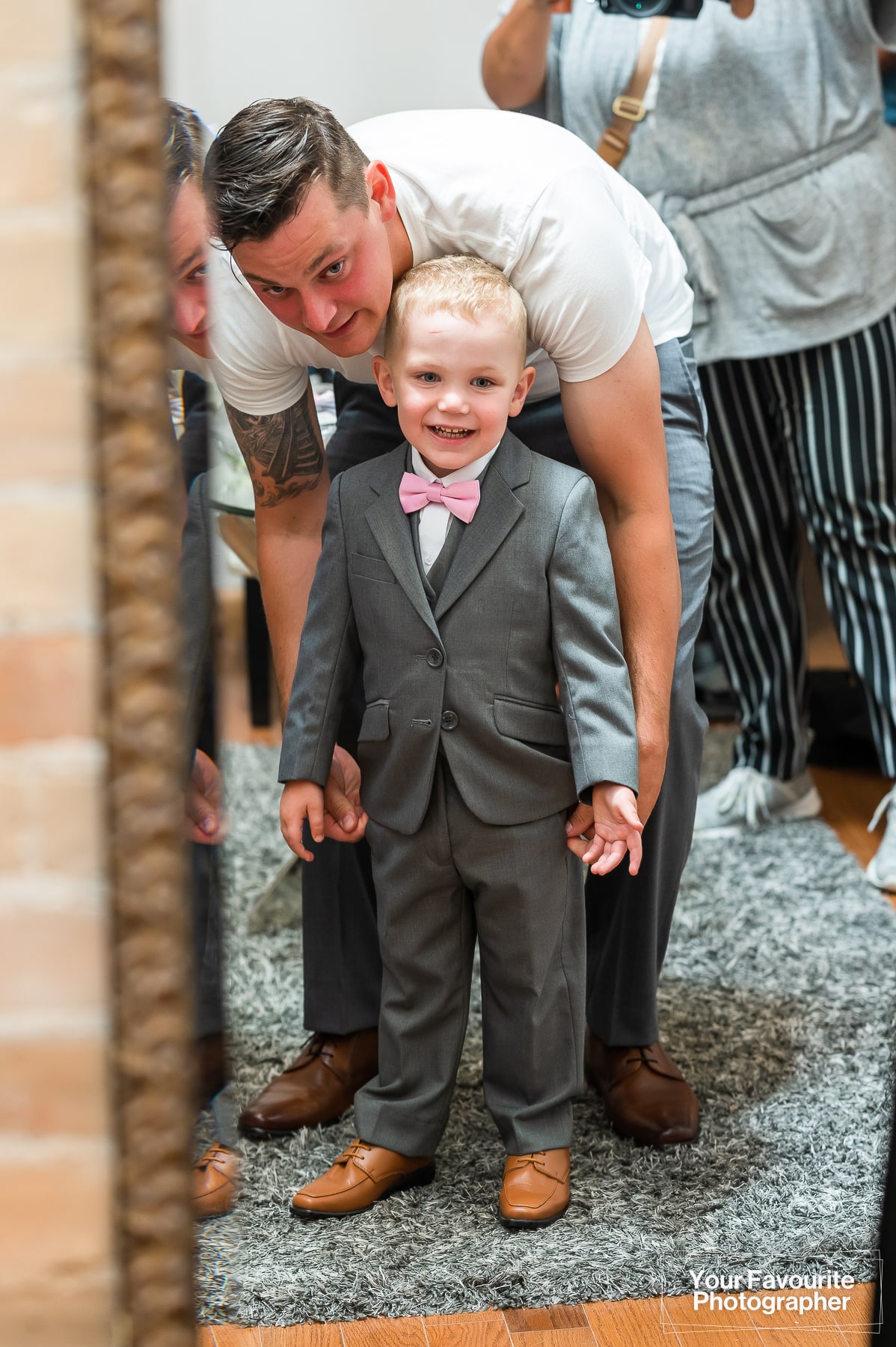 Groom and son looking in the mirror