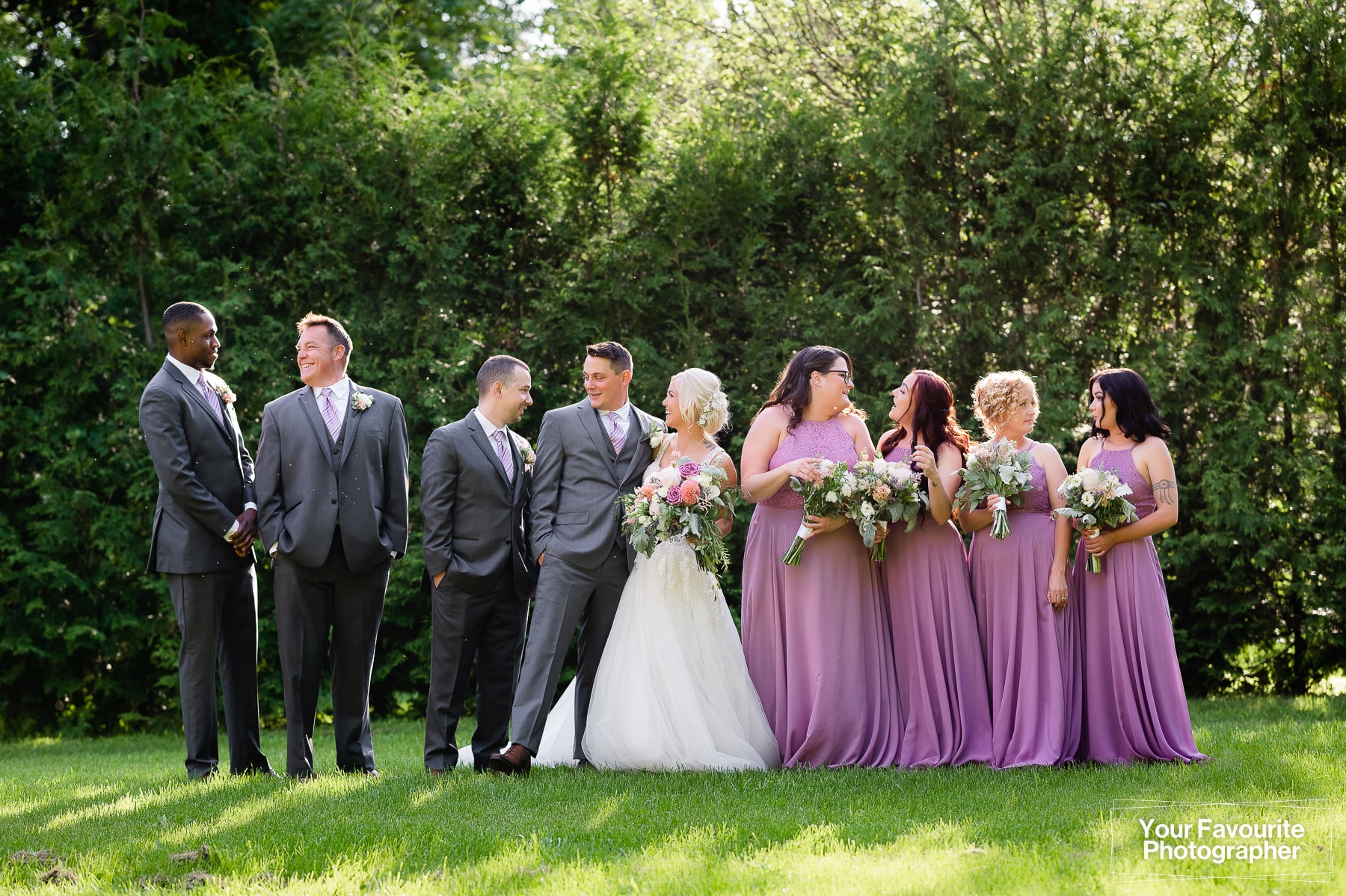 Candid group photo of wedding party outdoors in nature