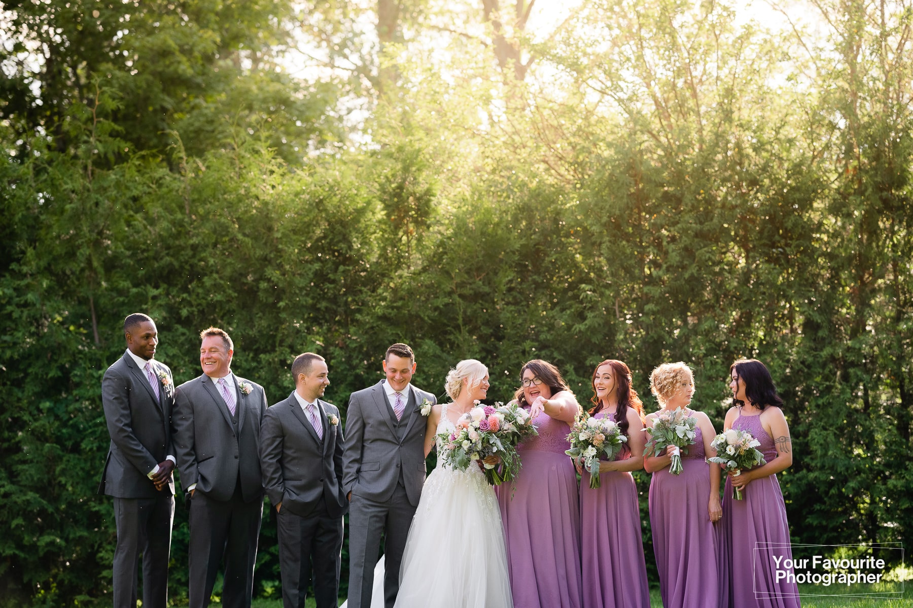 Candid group photo of wedding party outdoors in nature