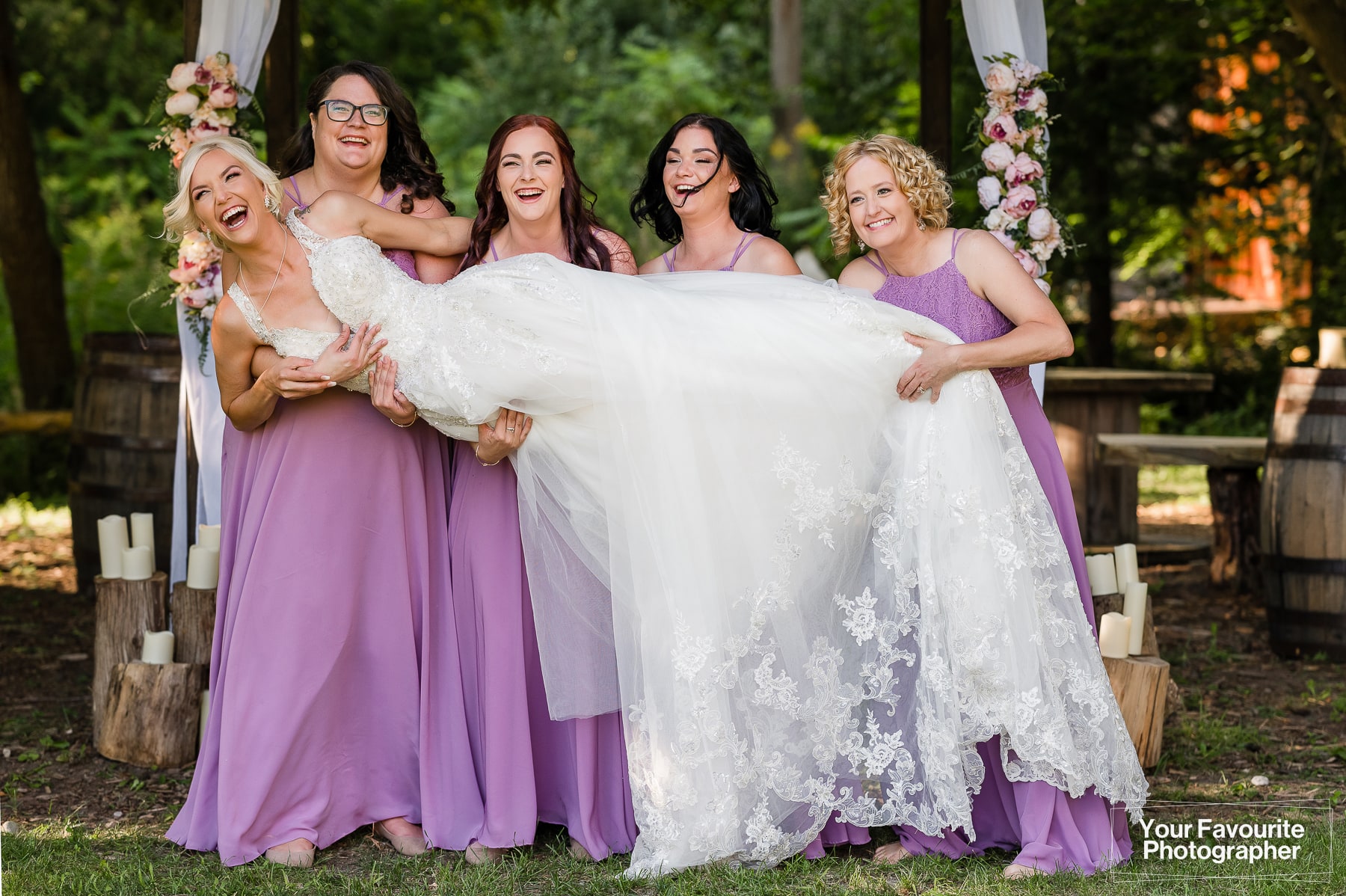 Bridesmaids attempting to lift bride