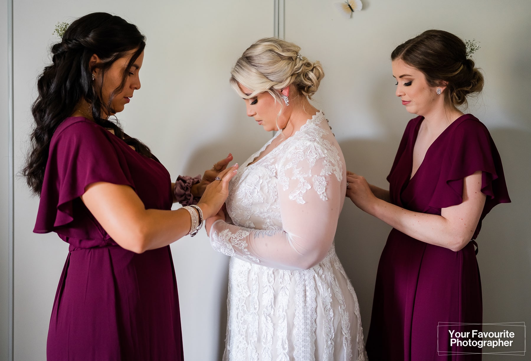 Bridesmaid helps with the wedding dress