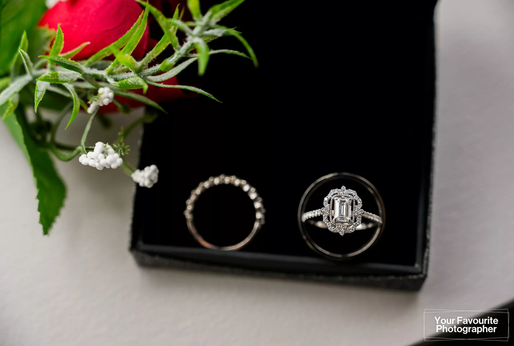 Macro photo of wedding rings in ring box with flowers
