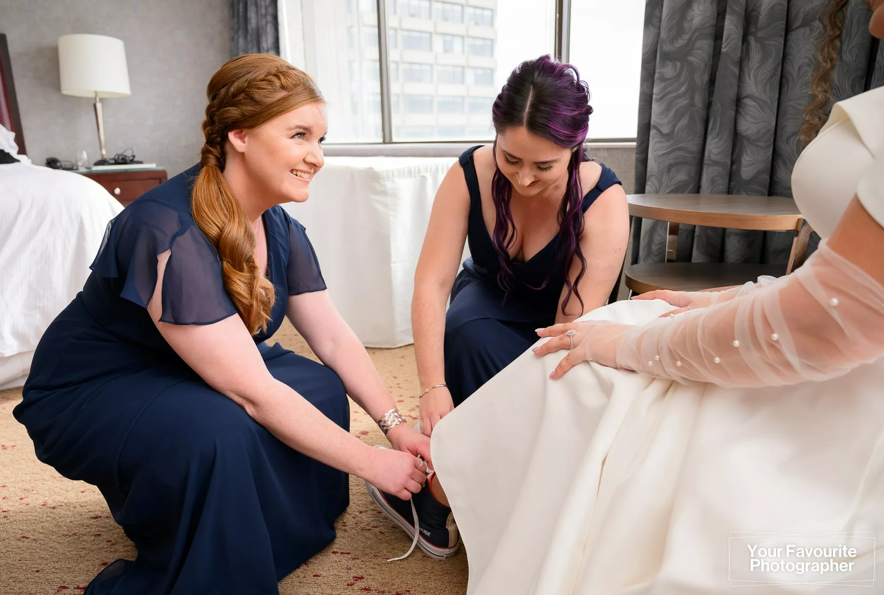 Bridesmaids helping bride put on her custom Chuck Taylor All-Star shoes
