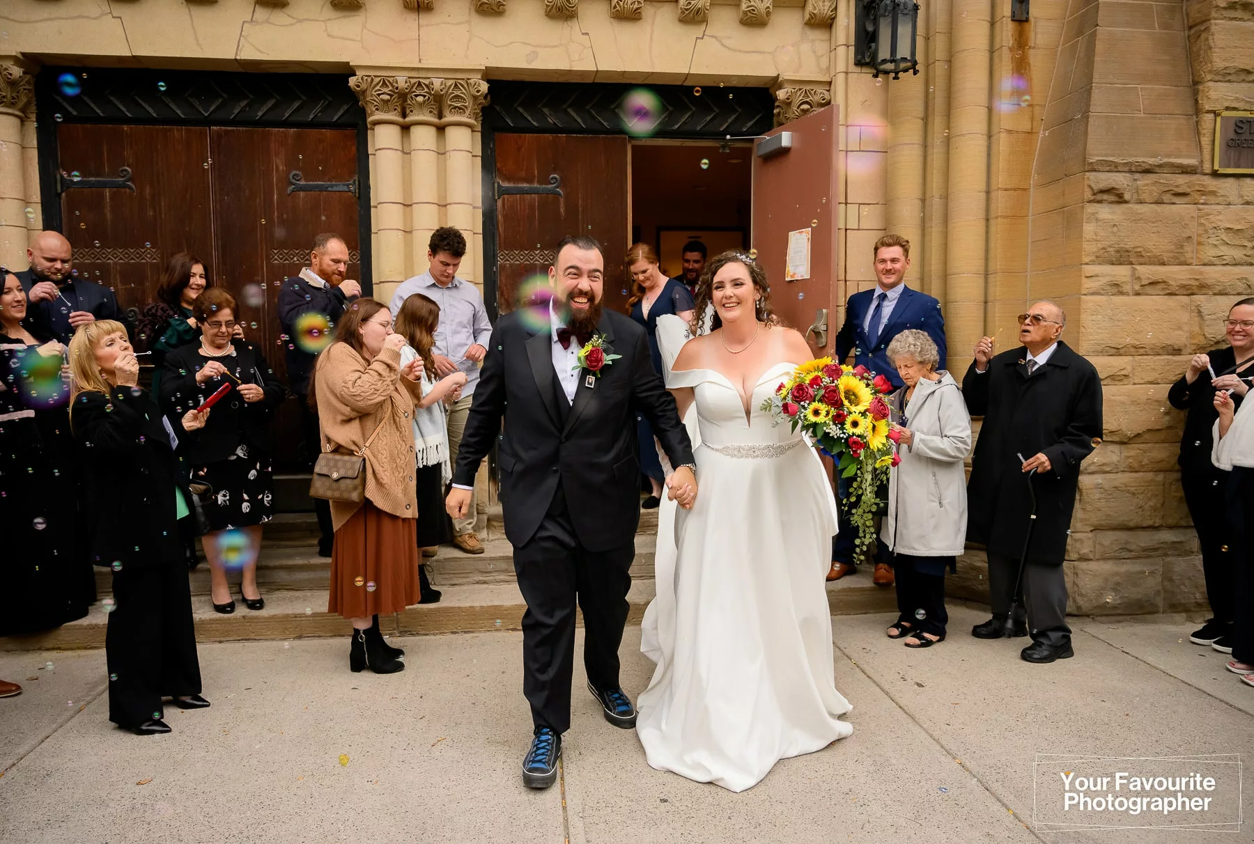 Bride and groom leaving St. George's Greek Orthodox Church in downtown Toronto, surrounded by people blowing bubbles