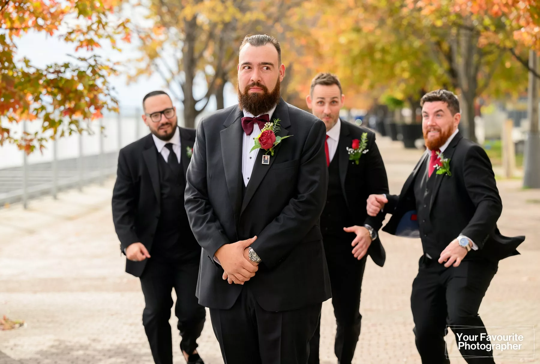 Photo of a groom with his groomsmen running towards him