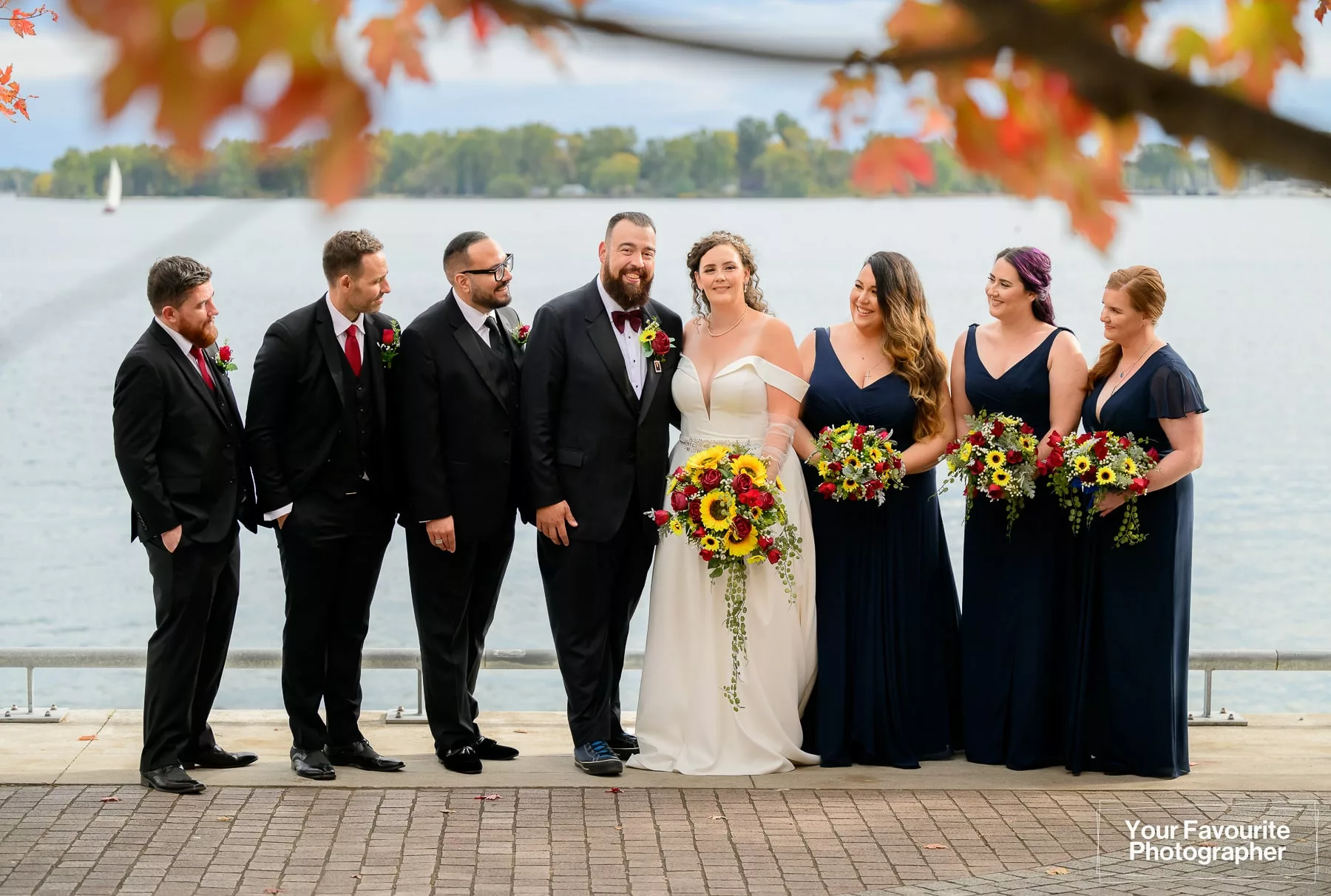Wedding party posing in front of Lake Ontario and the Toronto Islands on the Water's Edge Promenade in downtown Toronto