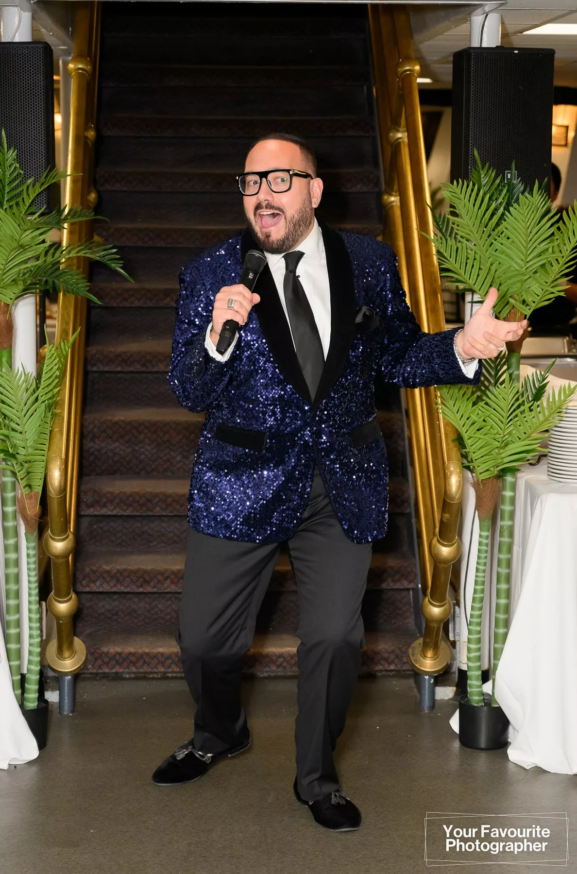 MC at a wedding in a flamboyant sparkly blue suit jacket