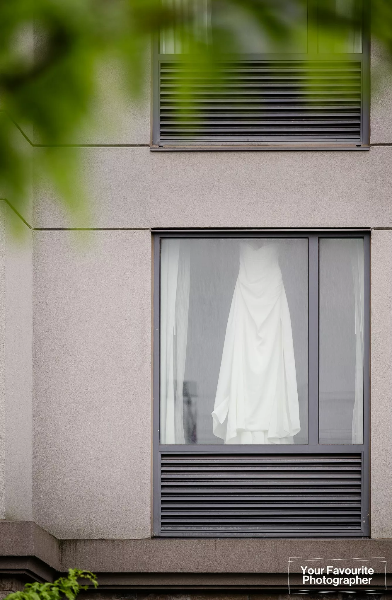 Wedding dress hanging in the window of the Hampton Inn and Suites by Hilton Bolton