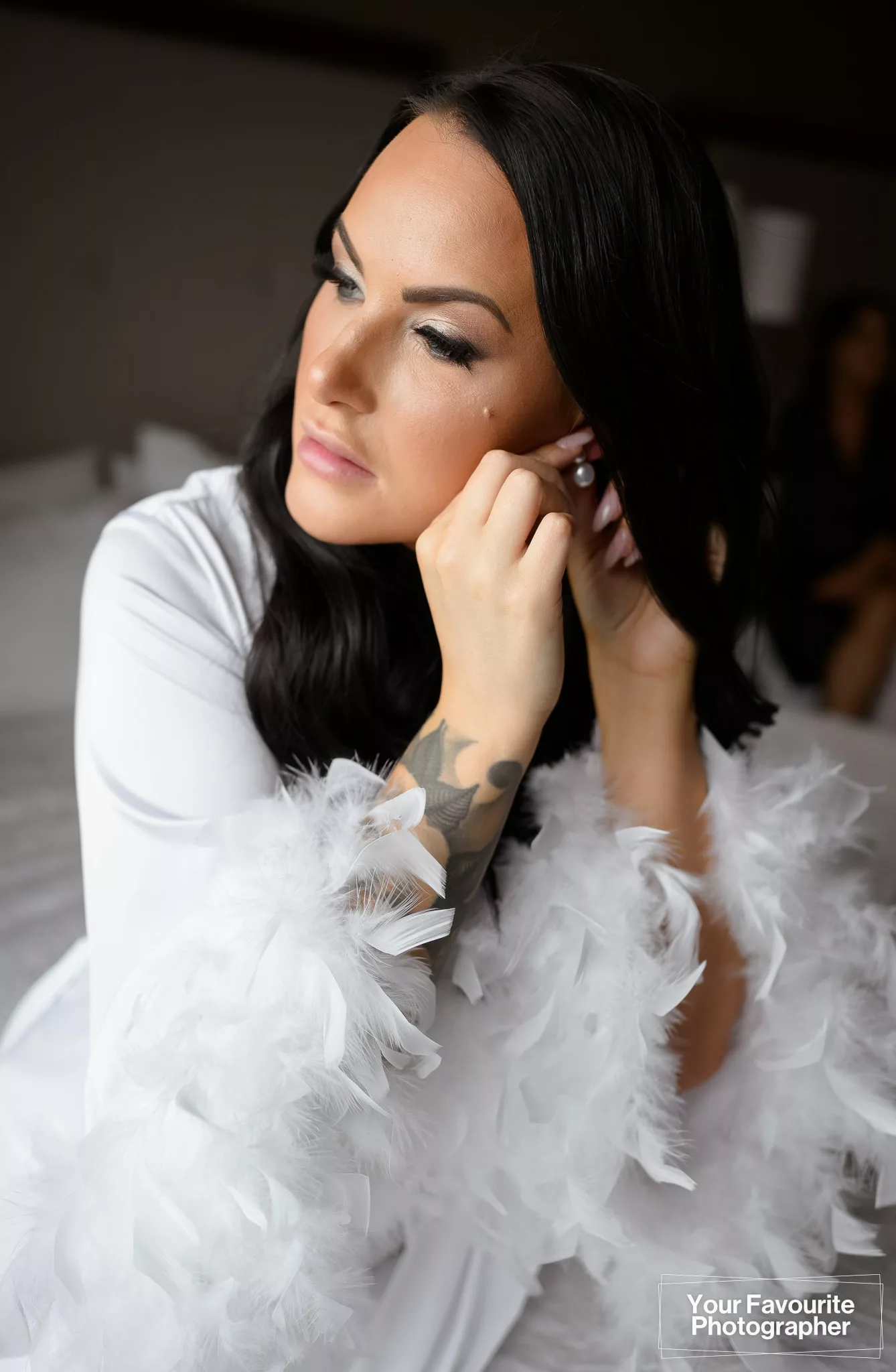 Bride fastening her earrings while getting ready for her wedding