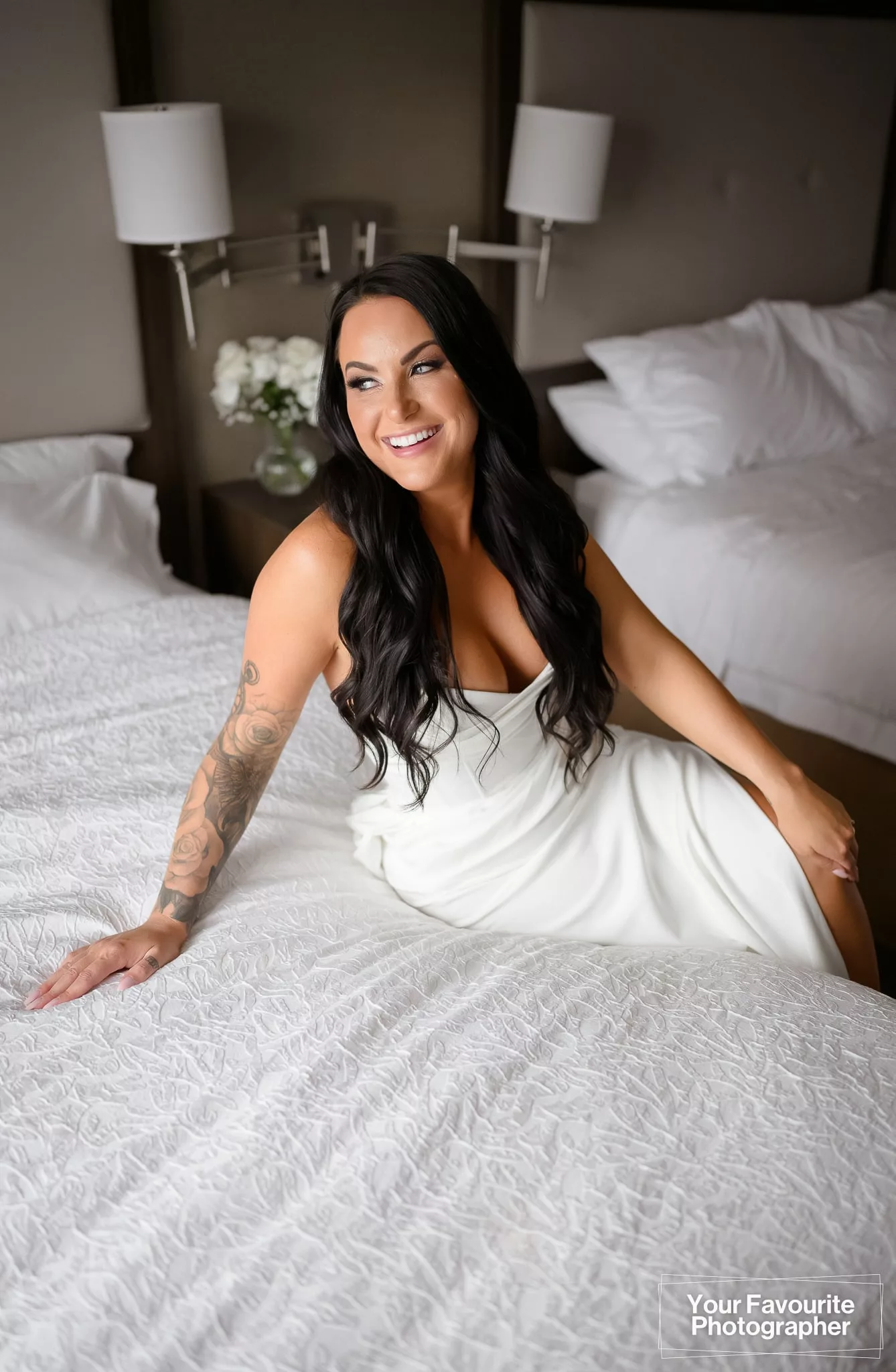 Beautiful bride posing on a bed at the Hampton Inn and Suites by Hilton Bolton on her wedding day