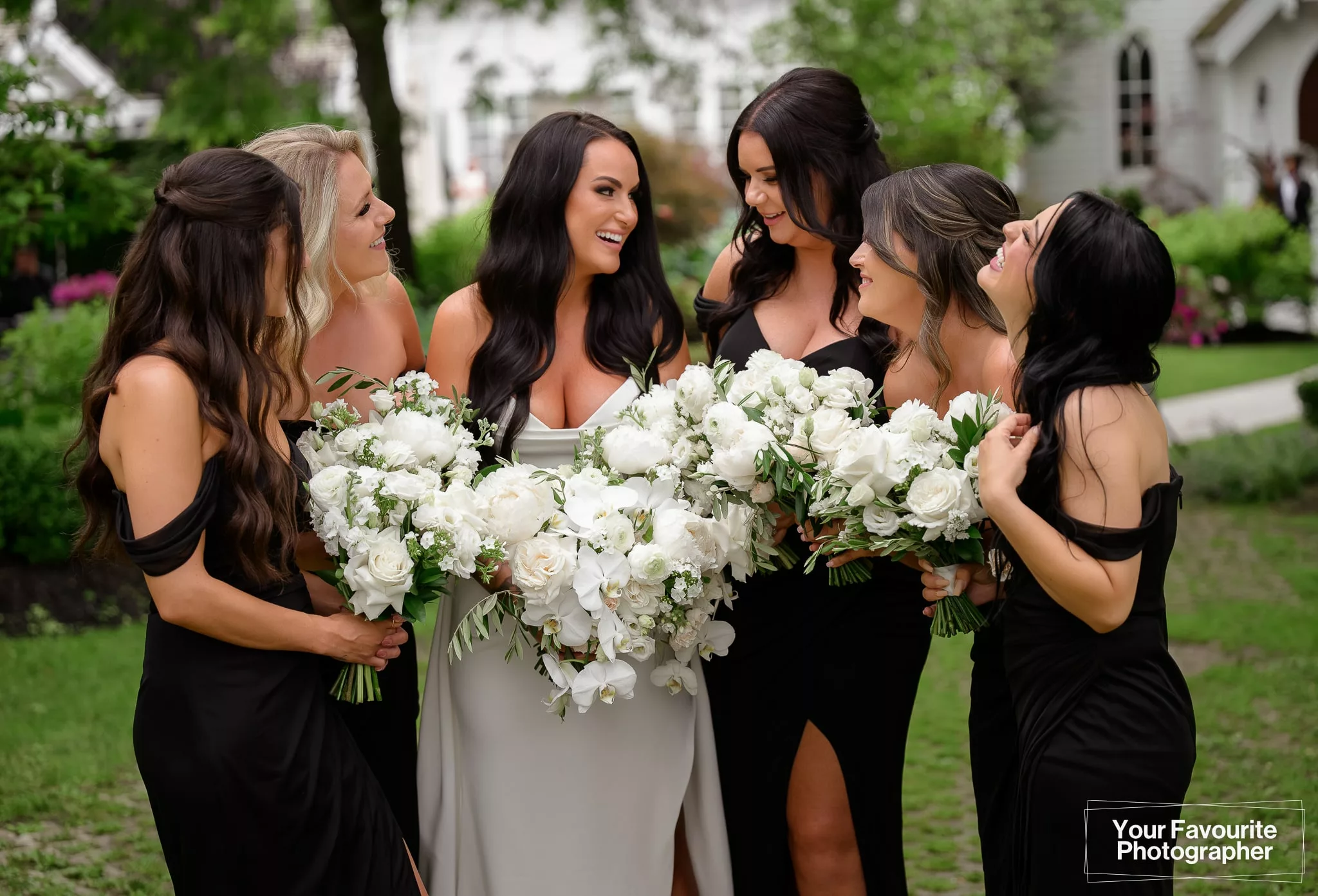 Bride with her bridesmaids in a black dresses and white flowers at The Doctor's House