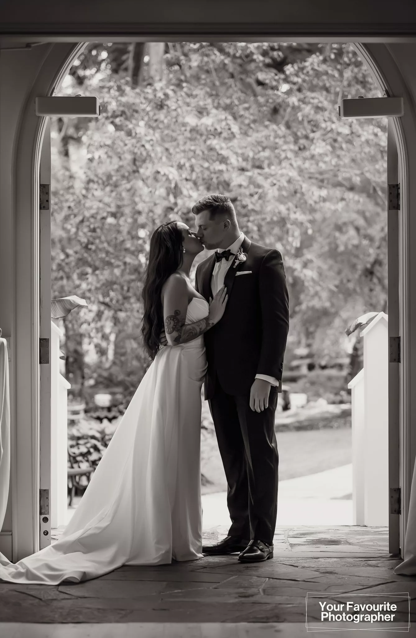 Bride and groom share a moment alone in the doorway of the chapel at The Doctor's House in Kleinburg
