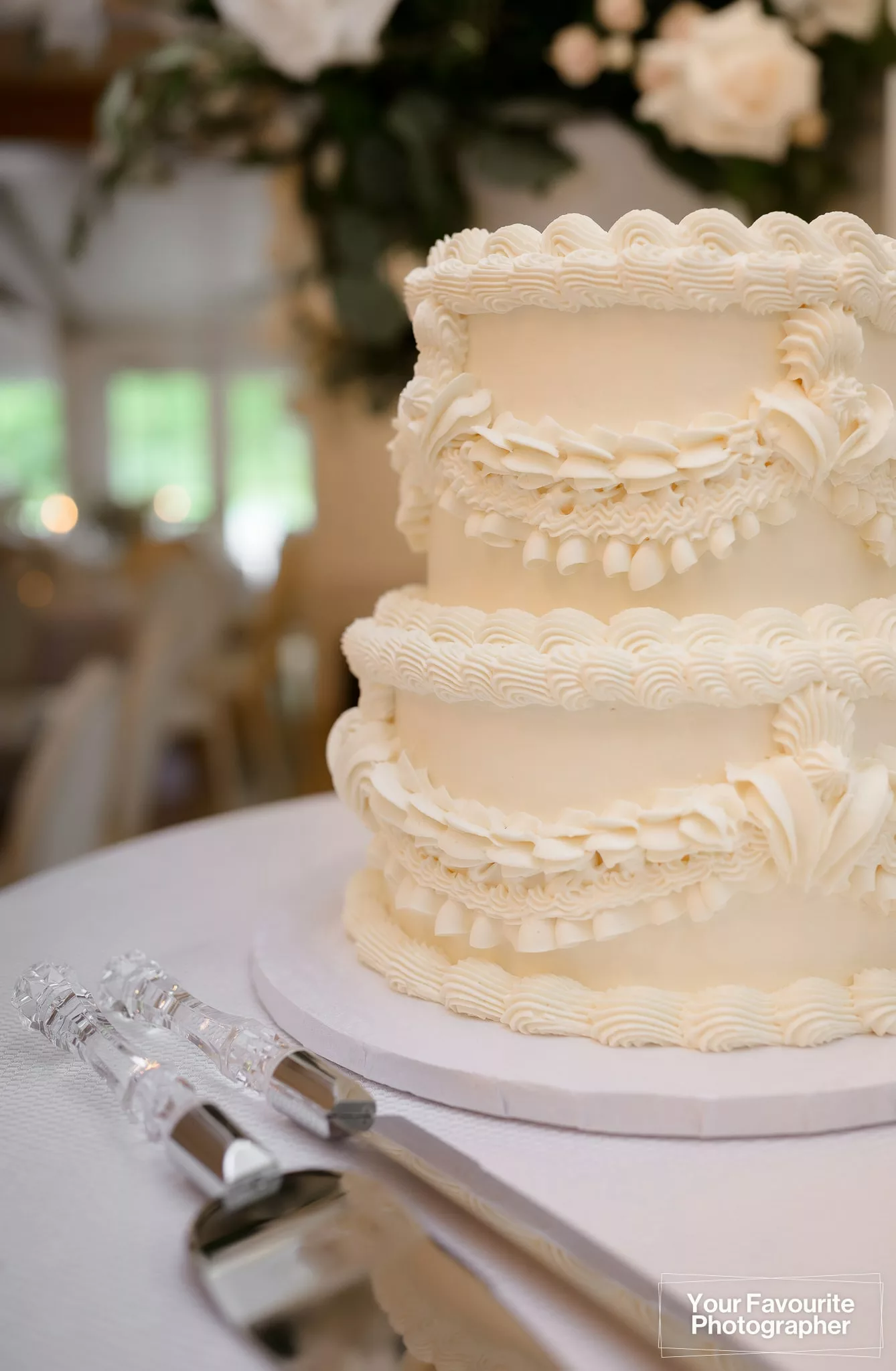 Close up of a simple, elegant white wedding cake with frosting