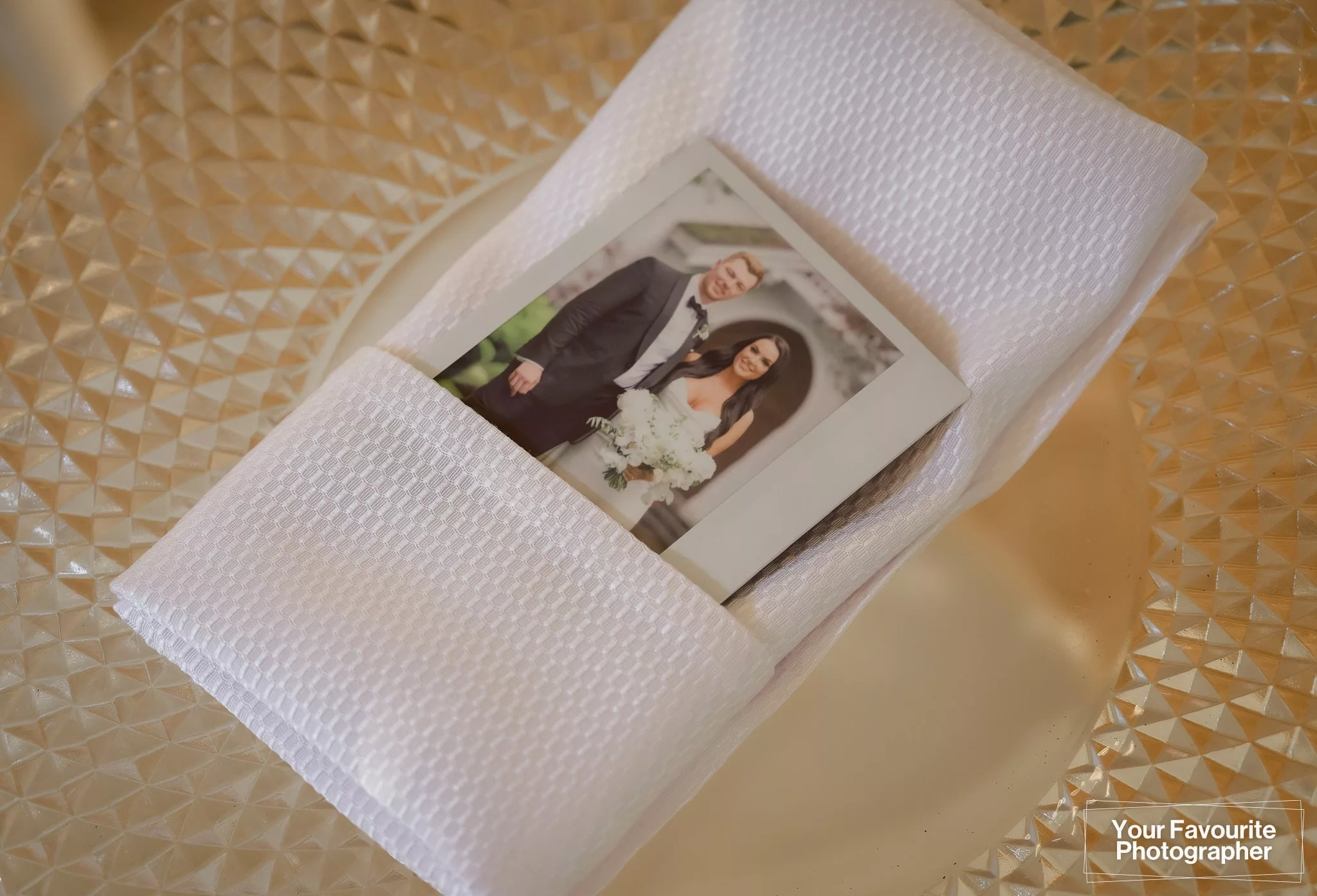Fuji Instax photo of a bride and groom tucked into a napkin