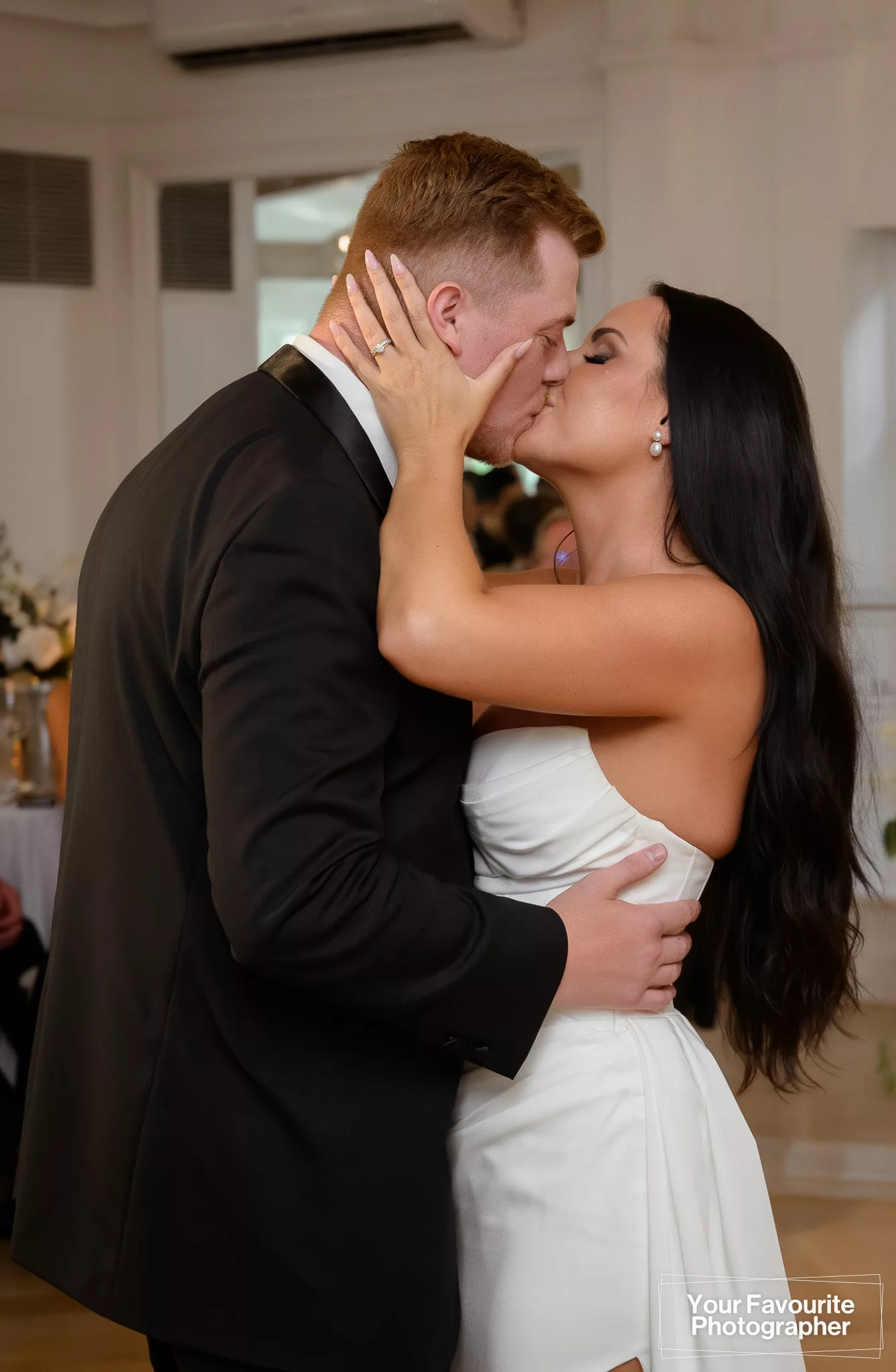 Bride and groom kiss during their first dance in the Garden Room at the Doctor's House