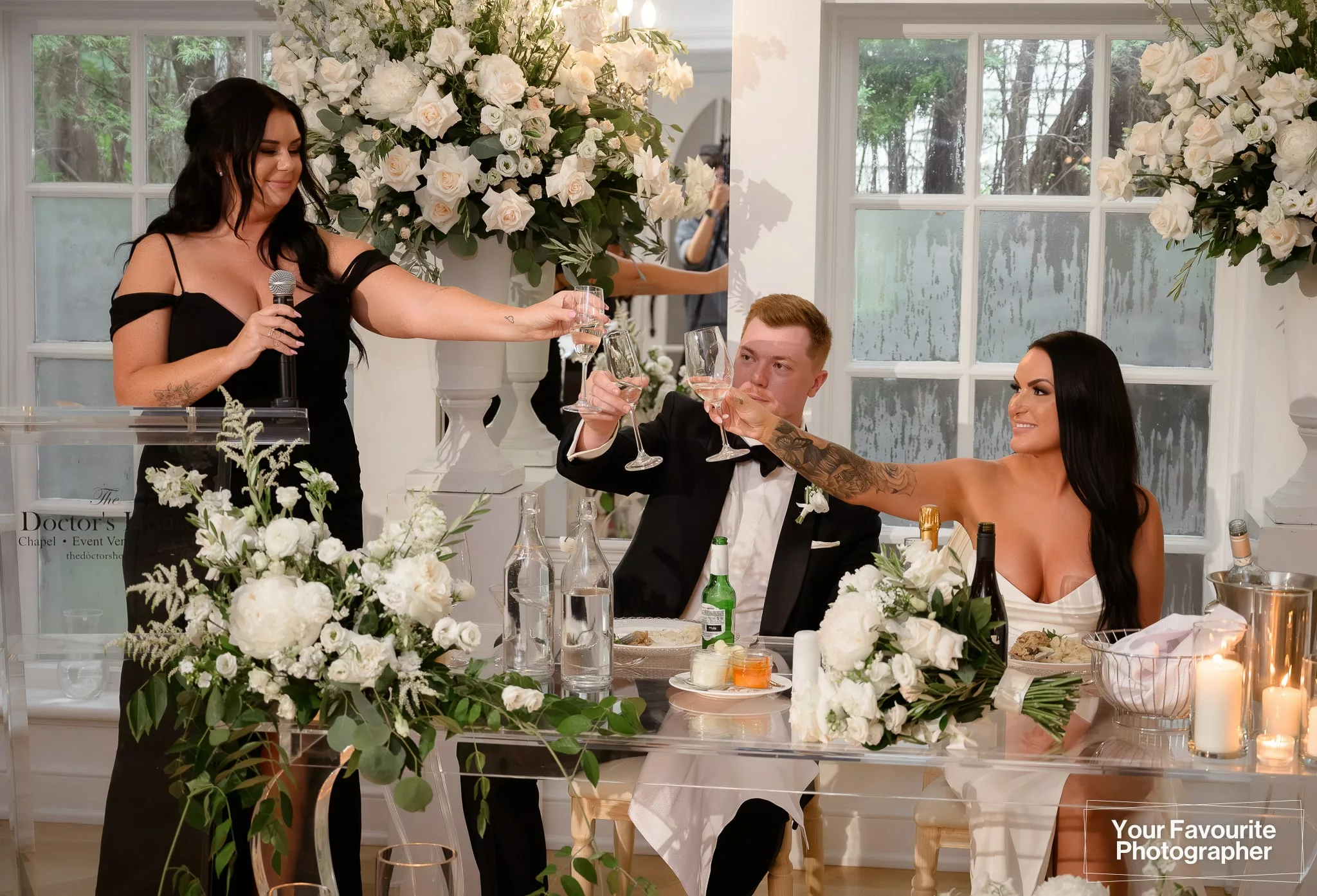 Bridesmaid, bride, and groom toast champagne during a speech