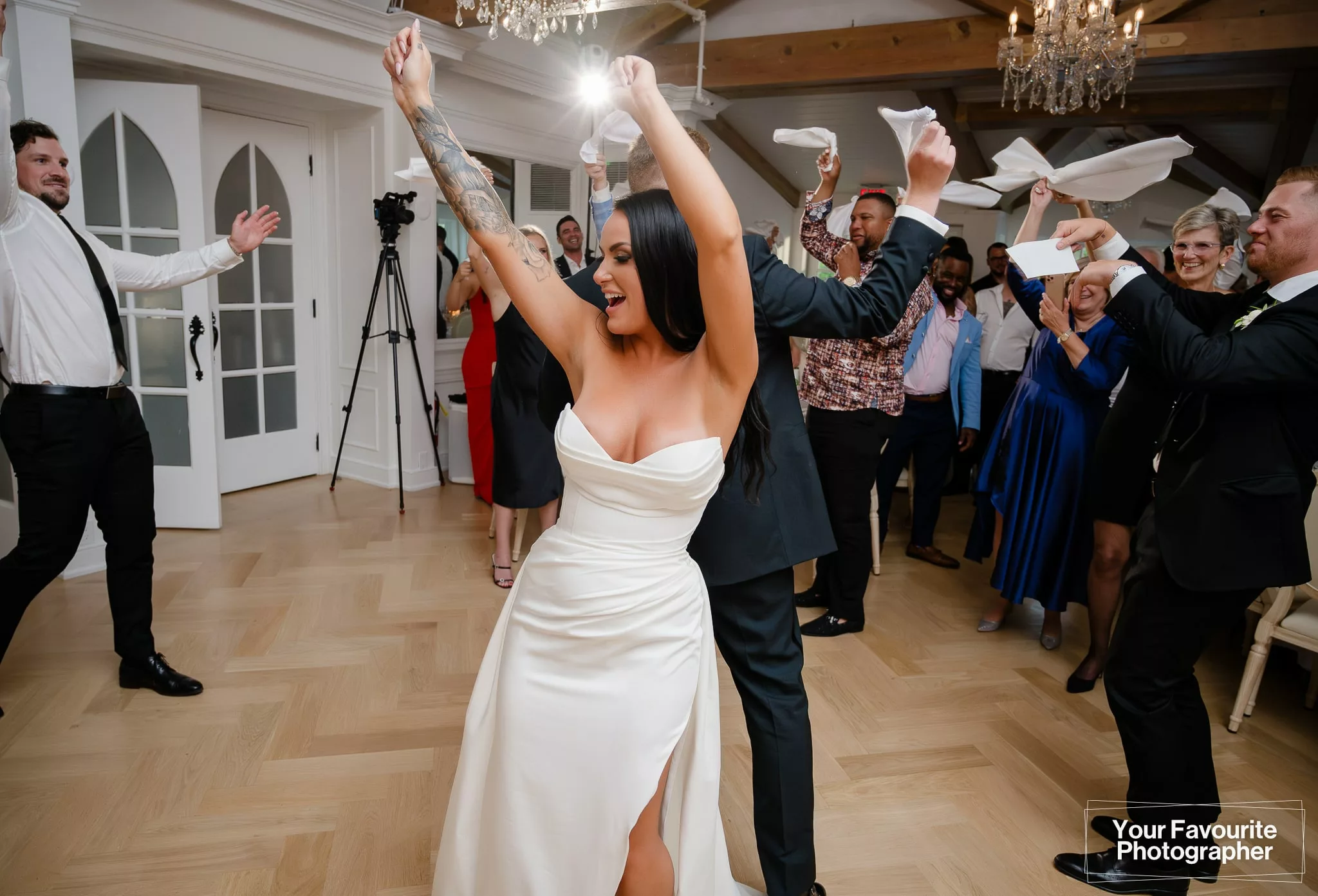 Bride dancing on the dance floor while people wave napkins around