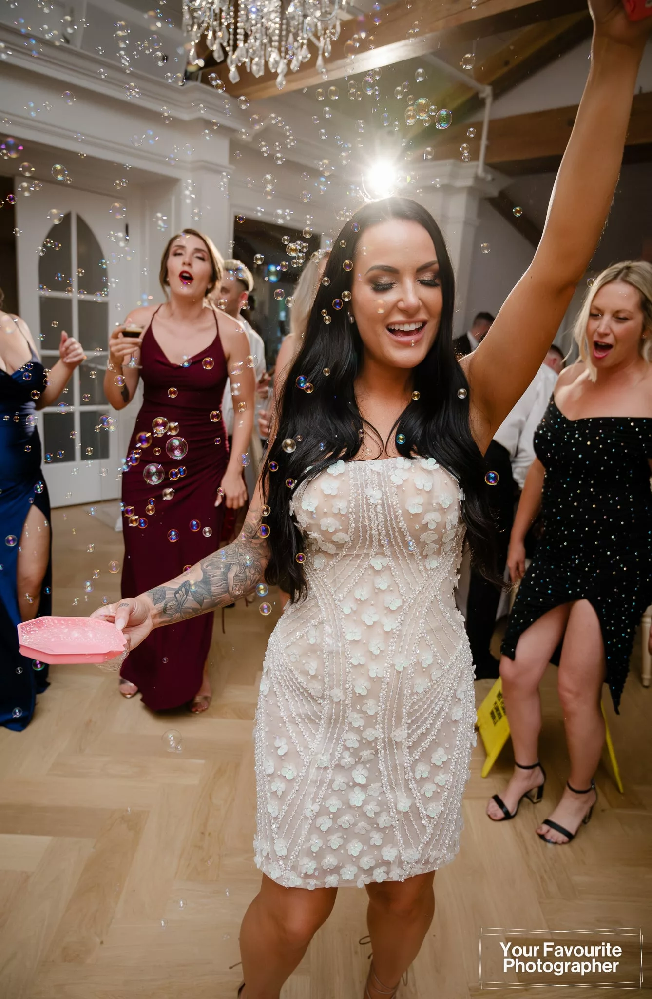 Bride Samantha uses a bubble gun to spray bubbles around the dance floor at her wedding reception