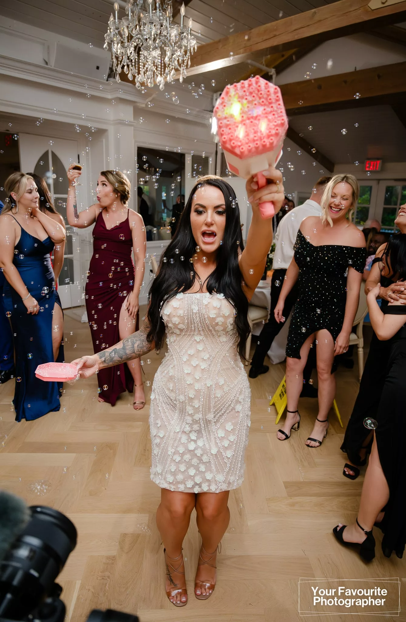 Bride Samantha uses a bubble gun to spray bubbles around the dance floor at her wedding reception