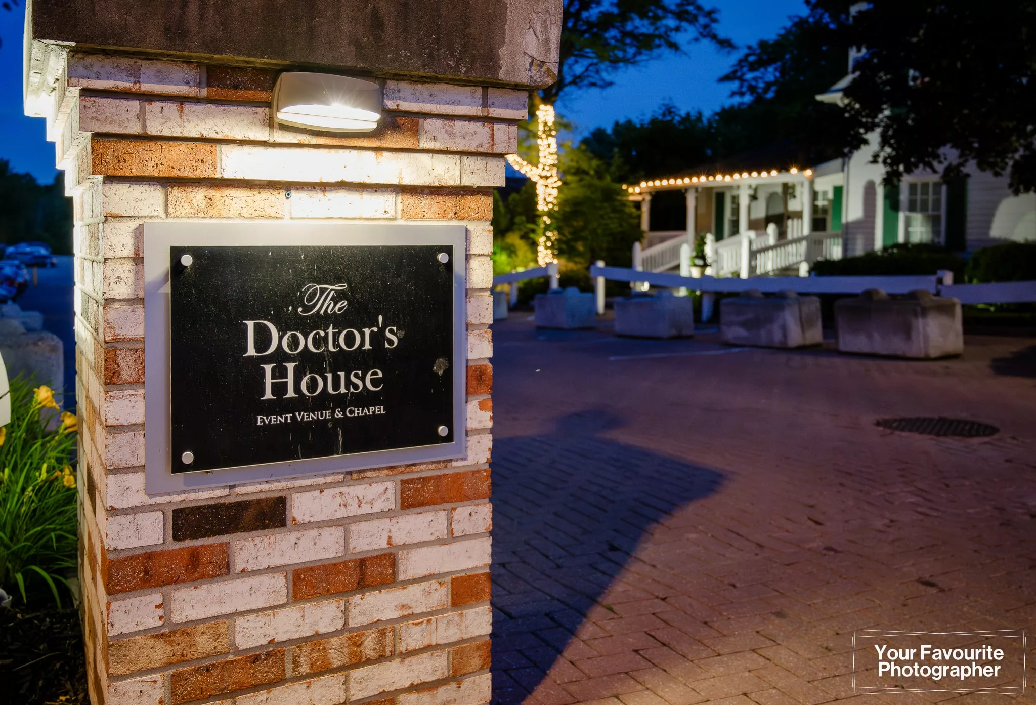 Sign outside The Doctor's House at night